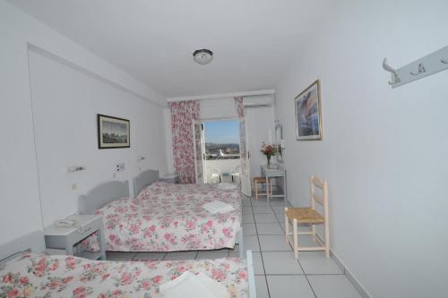 a bedroom with two beds and a table and chairs at King Thiras Hotel in Fira