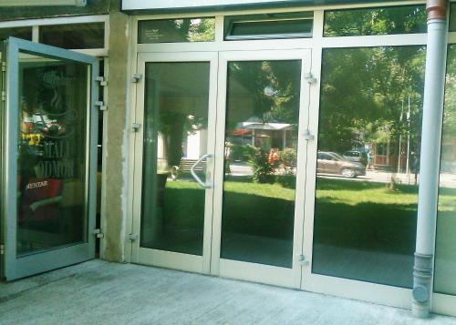 uma entrada para um edifício com portas de vidro deslizantes em Soba Centar em Banja Luka
