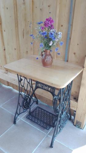 a table with a vase with flowers on it at Privat Kovacova in Žiar