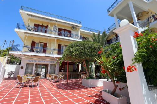 a large white building with a patio area at Hotel Karyatides in Agia Marina Aegina