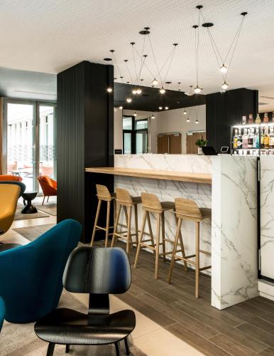 a kitchen with a bar with stools at Mercure Paris 17 Batignolles in Paris