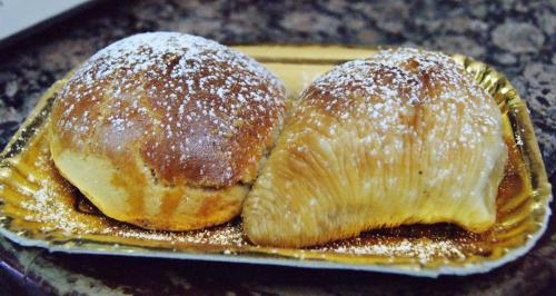 dos pasteles sentados en un plato con azúcar en polvo en Parthenope's home en Nápoles