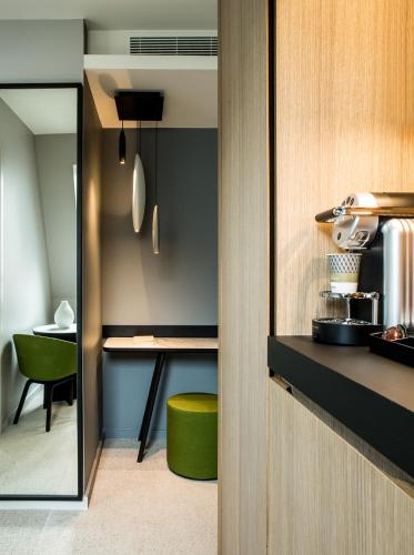 a kitchen with a green stool in a room at Mercure Paris 17 Batignolles in Paris