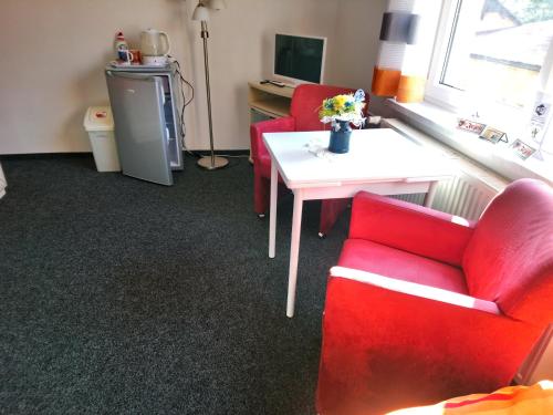 a living room with two red chairs and a table at Penzion u Krtka in Kraslice
