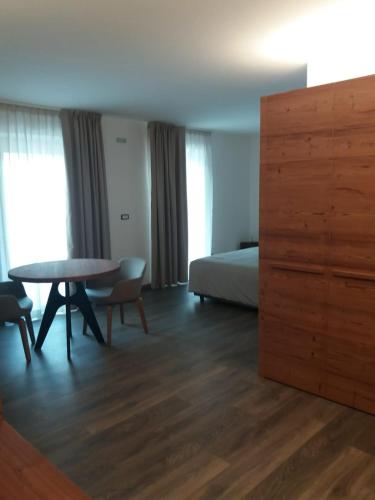 a hotel room with a bed and a table and a bedroom at B&B Al Castel in Padola