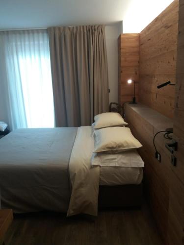 a bedroom with a large bed and a window at B&B Al Castel in Padola