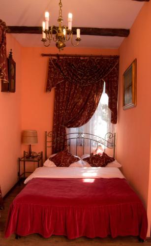 a bedroom with a red bed with a window at Bocianówka in Baranów Sandomierski