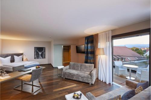 a hotel room with a bed and a living room at Schloss Reinach in Freiburg im Breisgau