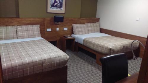 a hotel room with two beds and a tv at Leith House in Edinburgh