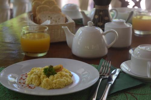 a plate of scrambled eggs and a glass of orange juice at Chalet Bamboo Vert in La Digue