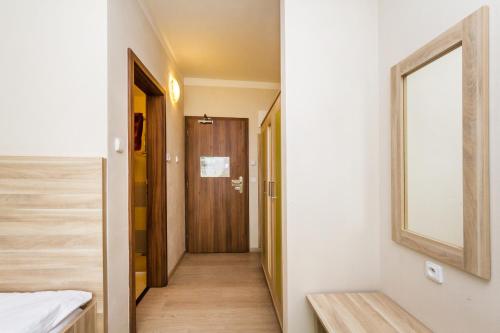 a hallway leading to a bedroom with a wooden door at Nad Královnou Hotel & Restaurant in Prague