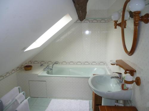a bathroom with a sink and a bath tub at Chambres d'hôtes Legros in Vierzon