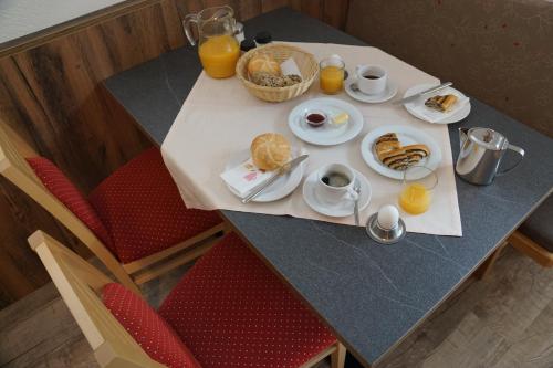 a table with breakfast foods and orange juice on it at Apart Felsenhof in Längenfeld