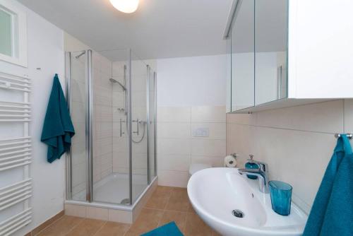 a white bathroom with a shower and a sink at Bergblick Appartement in Ober-Hambach