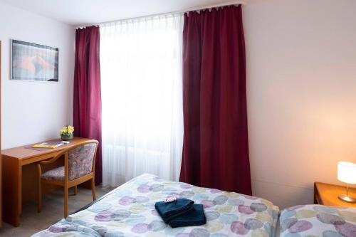 Zimmer mit einem Bett, einem Schreibtisch und einem Fenster in der Unterkunft Bergblick Appartement in Ober-Hambach