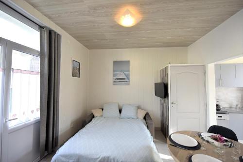 Un dormitorio con una cama y una mesa. en Appartement "Mer" - 50m Front de Mer, en Berck-sur-Mer