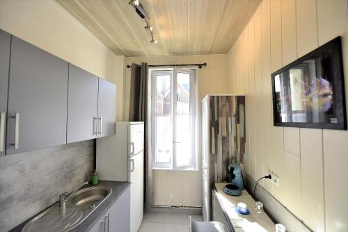 una pequeña cocina con fregadero y ventana en Appartement "Mer" - 50m Front de Mer, en Berck-sur-Mer