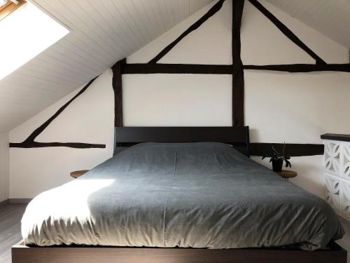 a bedroom with a large bed in a attic at Au Petit H in Stavelot