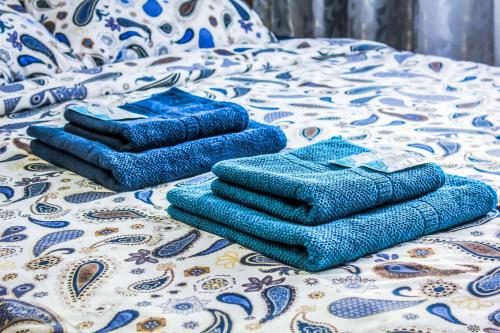 ケメロヴォにあるGUESTHOUSE Апартаменты Комфортのベッドの上に座る青いタオル2枚