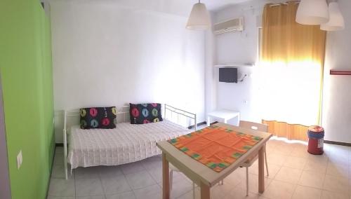 um pequeno quarto com uma cama e uma mesa em "Apartment 2" em Lerápetra