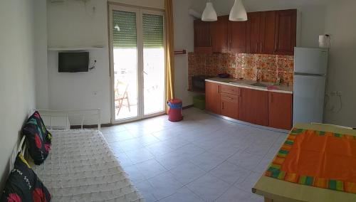 uma cozinha com piso em azulejo branco e um frigorífico em "Apartment 2" em Lerápetra