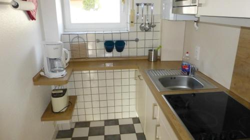 una piccola cucina con lavandino e finestra di Ferienwohnung Dangast a Varel