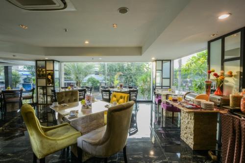 une salle à manger avec des chaises jaunes et une table dans l'établissement Royal Regantris Cendana Formerly Royal Singosari, à Surabaya