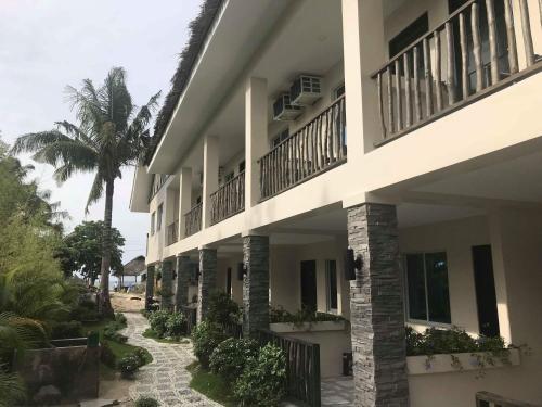 a building with a courtyard with a palm tree at Avila's Horizon Dive Resort Malapascua in Malapascua Island