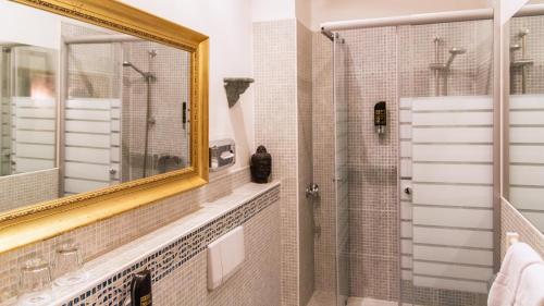 ein Bad mit einem Spiegel und einer Dusche in der Unterkunft Hotel Village in Hamburg