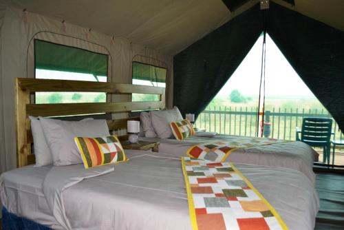 two beds in a room with a view of a balcony at Mwandi View in Kavimba