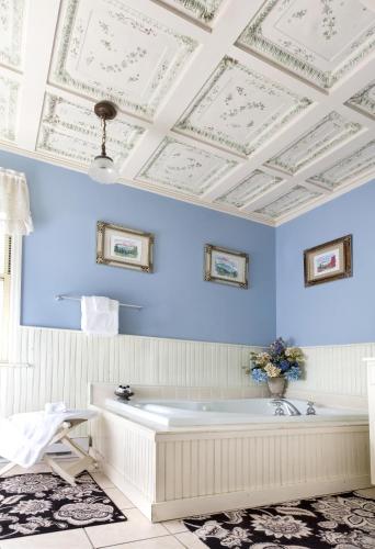 a bath tub in a bathroom with blue walls and a ceiling at The Reynolds Mansion in Asheville