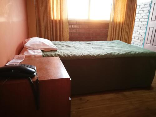a room with two beds and a desk with a telephone at Meflo Playa Grande in Chala