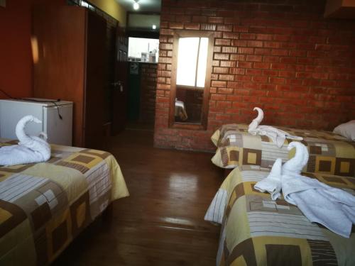 two swans sitting on two beds in a room at Meflo Playa Grande in Chala