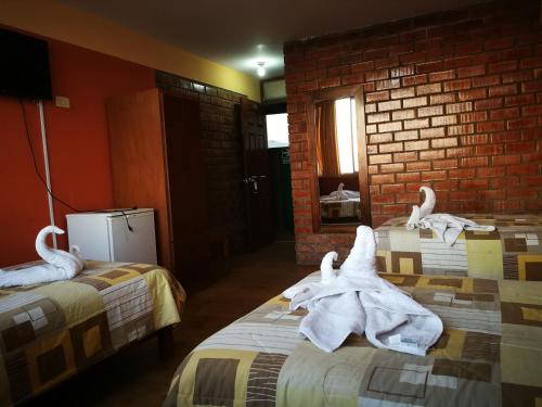 a room with two beds with towels on them at Meflo Playa Grande in Chala