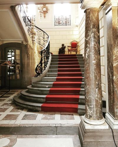 a staircase with a red carpet and a red rug at Château de Pourtalès in Strasbourg