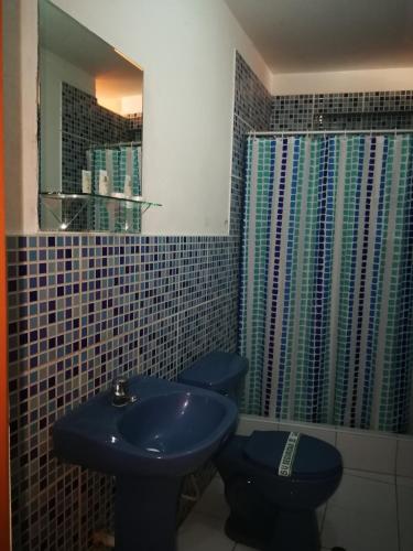 a bathroom with a blue sink and a toilet at Meflo Playa Grande in Chala