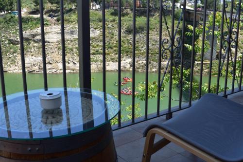 a balcony with a glass table and a chair at Iznájar Suites in Iznájar