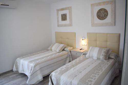1 dormitorio con 2 camas y vestidor en Iznájar Suites, en Iznájar
