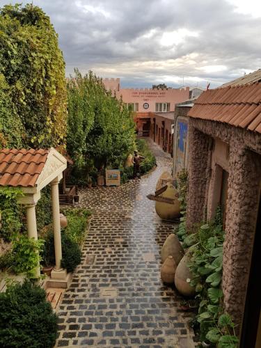 a cobblestone walkway in a courtyard with buildings at Machanents Art Hotel in Vagharshapat