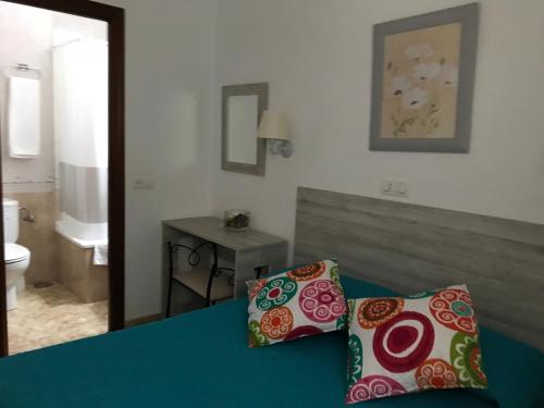 1 dormitorio con 1 cama con 2 almohadas en Hostal Argentina, en Cáceres