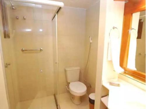 a bathroom with a toilet and a glass shower at FLAT - Residencial Pousada do Serrano in Gramado