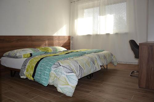 a bedroom with a bed with a wooden floor and a window at Na Zeleném statku in Rašovice