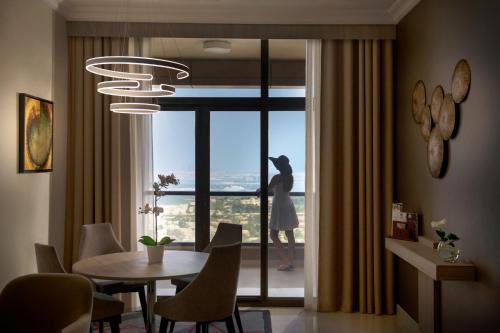 a dining room with a table and a large window at Two Seasons Hotel & Apartments in Dubai
