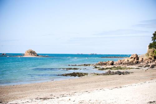a sandy beach with rocks in the water at Pontac House Hotel in St Clements