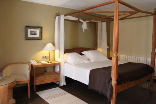 昆卡的住宿－昆卡酒店，一间卧室配有一张天蓬床和一张带台灯的桌子