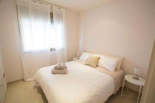- une chambre avec un lit blanc et des serviettes dans l'établissement Deluxe Playa Pacifico, à Malaga