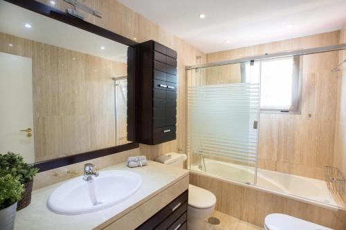 La salle de bains est pourvue d'un lavabo, d'une baignoire et de toilettes. dans l'établissement Deluxe Playa Pacifico, à Malaga