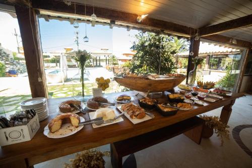 un tavolo pieno di diversi tipi di pane e dolci di Pousada Casa do Catavento a Búzios