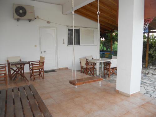a patio with a table and chairs and a porch at Glaros Studios in Loutra Edipsou