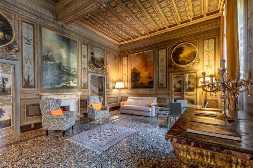 a living room with a fireplace and paintings on the walls at Casa Borghese by Burghesius in Rome